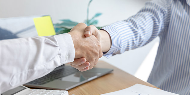 Dos empresarios se dan la mano cerrando negocio de sus empresas