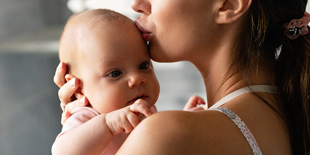 Una madre sostiene a su hijo bebé en brazos