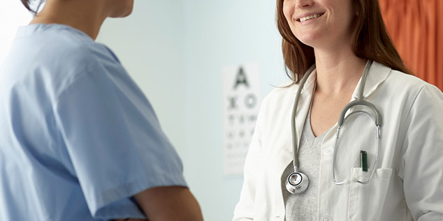 Una médico atiende a una paciente en una consulta de salud